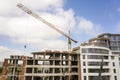 Apartment or office tall building under construction. Brick walls, glass windows, scaffolding and concrete support pillars. Tower Royalty Free Stock Photo