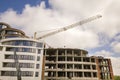 Apartment or office tall building under construction. Brick walls, glass windows, scaffolding and concrete support pillars. Tower Royalty Free Stock Photo