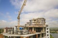 Apartment or office tall building under construction. Brick walls, glass windows, scaffolding and concrete support pillars. Tower Royalty Free Stock Photo