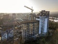 Apartment or office tall building under construction, top view. Tower crane and city landscape stretching to horizon. Drone aerial Royalty Free Stock Photo