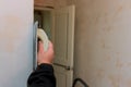 Apartment renovation with worker applies a grinding spatula to the wall checking levelling Royalty Free Stock Photo