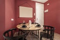 Apartment with round wooden dining table, food service, black chairs,