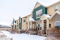 Apartment on snowy neighborhood with Christmas lights and wreaths at the facade