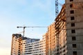 Tower crane constructing a new residential building at a construction site against blue sky Royalty Free Stock Photo