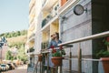 Apartments for rent. Vacation Europe Travel Tourism. A girl in a dress stands near the entrance to a small cozy European hotel.