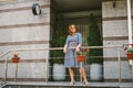 Apartments for rent. Vacation Europe Travel Tourism. A girl in a dress stands near the entrance to a small cozy European hotel.