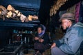 Apatani tribal couple at their home near fire place cooking food at evening from flat angle