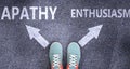 Apathy and enthusiasm as different choices in life - pictured as words Apathy, enthusiasm on a road to symbolize making decision