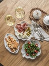 Aperitif, tapas, appetizer arugula table, cherry salad, plate with prosciutto, olives, cheese and breadsticks, cracker on a wooden Royalty Free Stock Photo