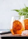 Aperol spritz cocktail in glass with sparkling wine, liqueur, ice and sicilian orange - summer alcohol drink, gray bar counter