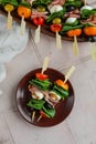 Apetizers on wooden skewers. Snacks from mozzarella, cherry tomatoes, salmon, spinach and olives.