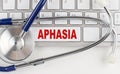 APHASIA word with Stethoscope on keyboard on grey background