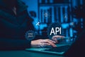 API Application Programming Interface concept. Person using laptop with digital gear icons, representing software integration, Royalty Free Stock Photo