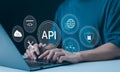 API Application Programming Interface Concept. A programmer types on a laptop, interacting with digital icons representing API Royalty Free Stock Photo