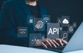 API Application Programming Interface Concept. A programmer types on a laptop, interacting with digital icons representing API Royalty Free Stock Photo