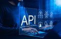 API Application Programming Interface Concept. A programmer types on a laptop, interacting with digital icons representing API Royalty Free Stock Photo