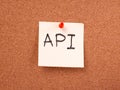 API written on a sticky note on a cork board Royalty Free Stock Photo