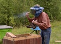 Apiary in the Carpathians. Beekeeper preparing a smoker for fumigating bees