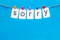 Apologise concept. Cute heart icons garland with text sorry on blue background top view copy space Royalty Free Stock Photo