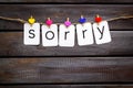 Apologise concept. Cute heart icons garland with text sorry on dsrk wooden background top view space for text Royalty Free Stock Photo