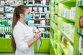 Apothecary looking at medicaments with checklist in drugstore