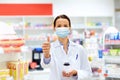 Apothecary in mask showing thumbs up at pharmacy Royalty Free Stock Photo