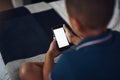 This app is the best for growing kids. a young boy using a cellphone while sitting on his bed.