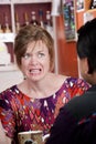 Appalled woman in coffee house with male friend