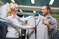 Apparel shopping. seller demonstrates formal suit to man in store