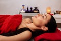 Appealing dark-haired female with ponytail calmly resting in massage cabinet