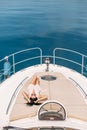 Appealing woman tanning on yacht, enjoying sunlight, posing on deck of sailboat Royalty Free Stock Photo
