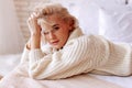 Appealing young woman with wavy hair wearing beige sweater