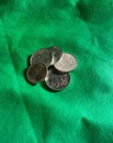 the appearance of coins that are stacked on a stretch of green cloth