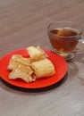 the appearance of a glass of hot tea and a plate of snacks on a wooden table Royalty Free Stock Photo