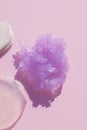 Appearance of the texture of the lilac sugar scrub on pink background. Cosmetic smear.