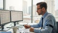 He appears focused working with two computer monitors displaying spreadsheets Royalty Free Stock Photo
