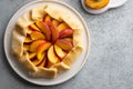 Appetite summer peach galeta on white table with copy space. summer open tart photo for cook book or food blog. Royalty Free Stock Photo