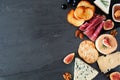 Assorted cheeses and meats, top view side border on a dark background with copy space