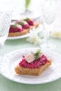 Appetizer with beetroot pesto and slice of herring on festive table Royalty Free Stock Photo