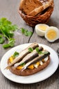 Appetizer bread with sprats and egg on white plate