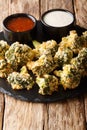 Appetizer of breaded broccoli baked with parmesan served with sauces. vertical