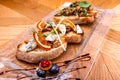 Appetizer bruschetta with cheese, honey, walnut and dry orange slices on wooden table. Close-up. Royalty Free Stock Photo