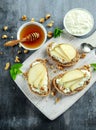 Appetizer bruschetta with pear, honey, walnut and cottage cheese on white board. Royalty Free Stock Photo