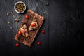 Appetizer bruschetta with tuna, capers and tomatoes on wholemeal bread. Italian cuisine, Delicious breakfast or snack on a dark Royalty Free Stock Photo