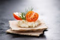 Appetizer canape with cherry tomato, cheese and dill on a small loaf of bread