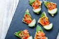 Appetizer canape with chopped vegetables and sesame on stone slate background close up. Royalty Free Stock Photo