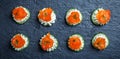 Appetizer canape with salmon, cucumber and cream cheese on stone slate background close up Royalty Free Stock Photo