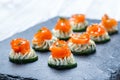 Appetizer canape with salmon, cucumber and cream cheese on stone slate background close up. Royalty Free Stock Photo