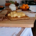 Appetizer with cheese cubes on wooden board- Royalty Free Stock Photo