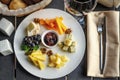 Appetizer `Cheese plate` with nuts and wineglass on a dark background. Royalty Free Stock Photo